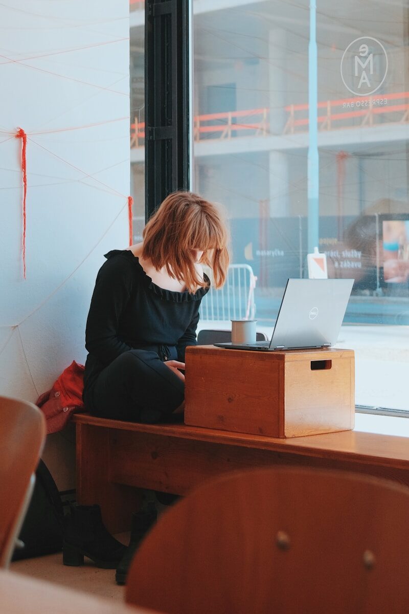 Menokind - Fakta om overgangsalderen på arbejdspladsen — og hvad du kan gøre, hvis symptomerne rammer dig a person sitting at a desk with a laptop