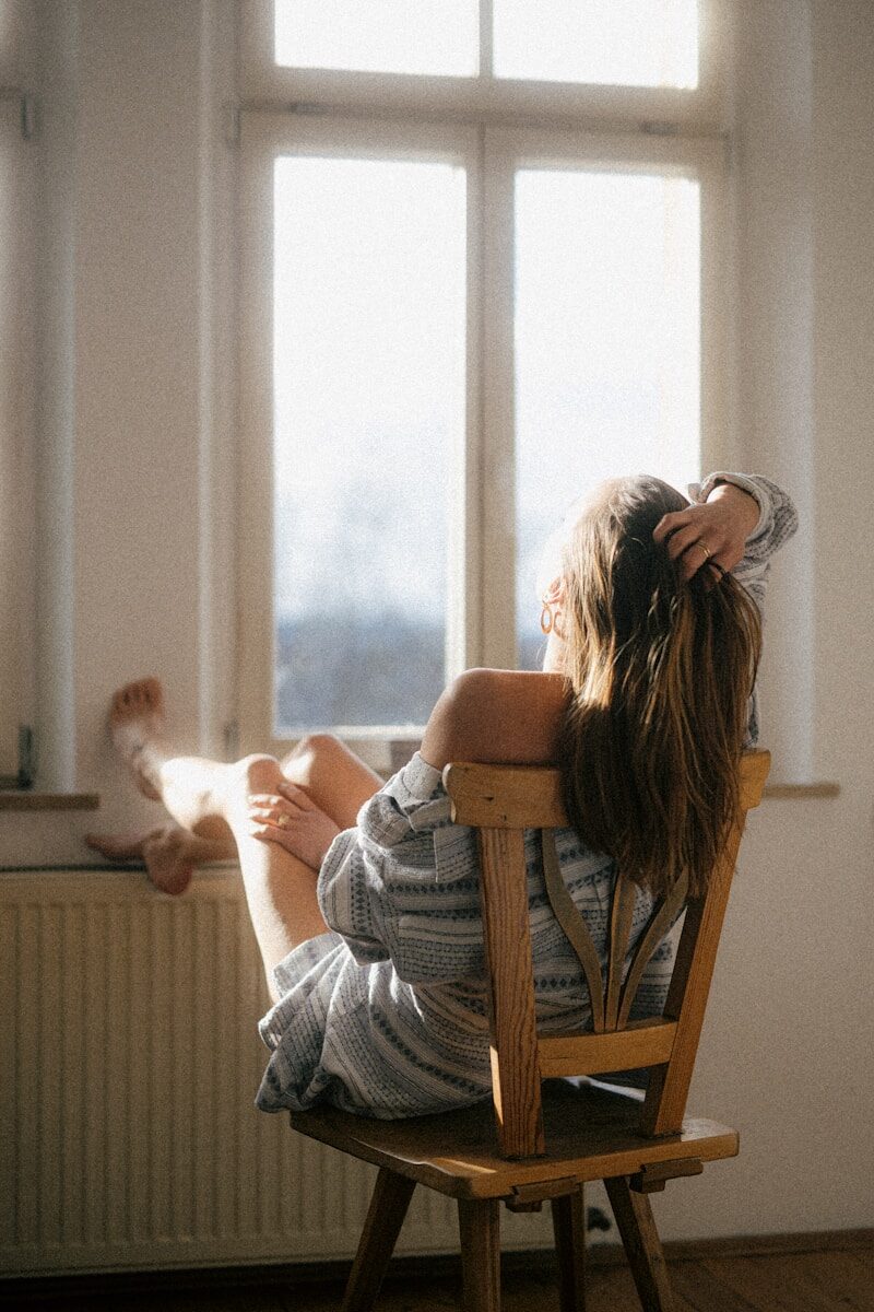 Menokind - Fakta om perimenopause — hedeture, humørsvingninger og alt derimellem a woman sitting in a chair reading a book