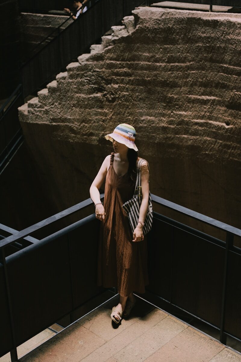 A woman wearing a hat standing on a balcony