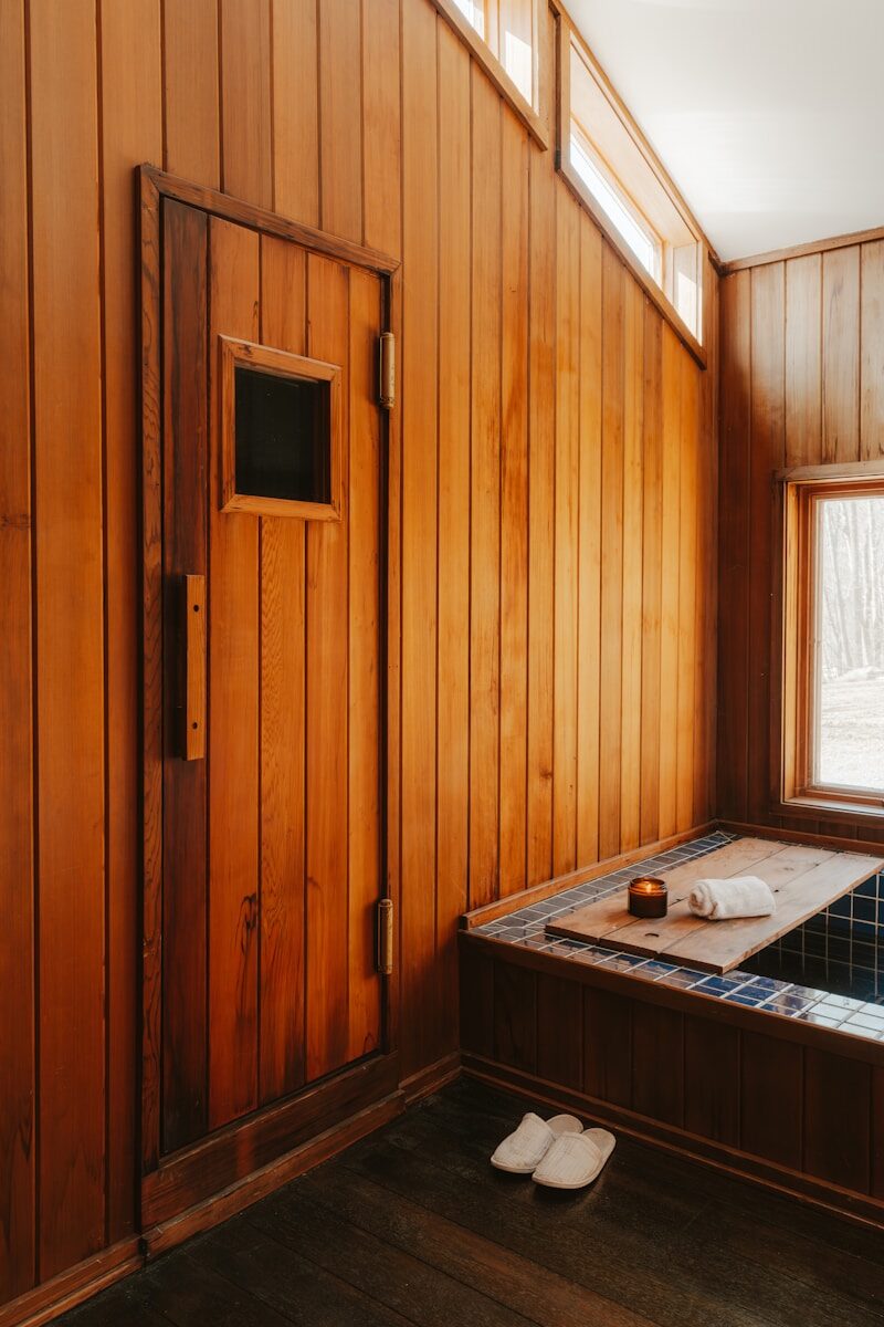 Wooden sauna room with a bathtub and slippers