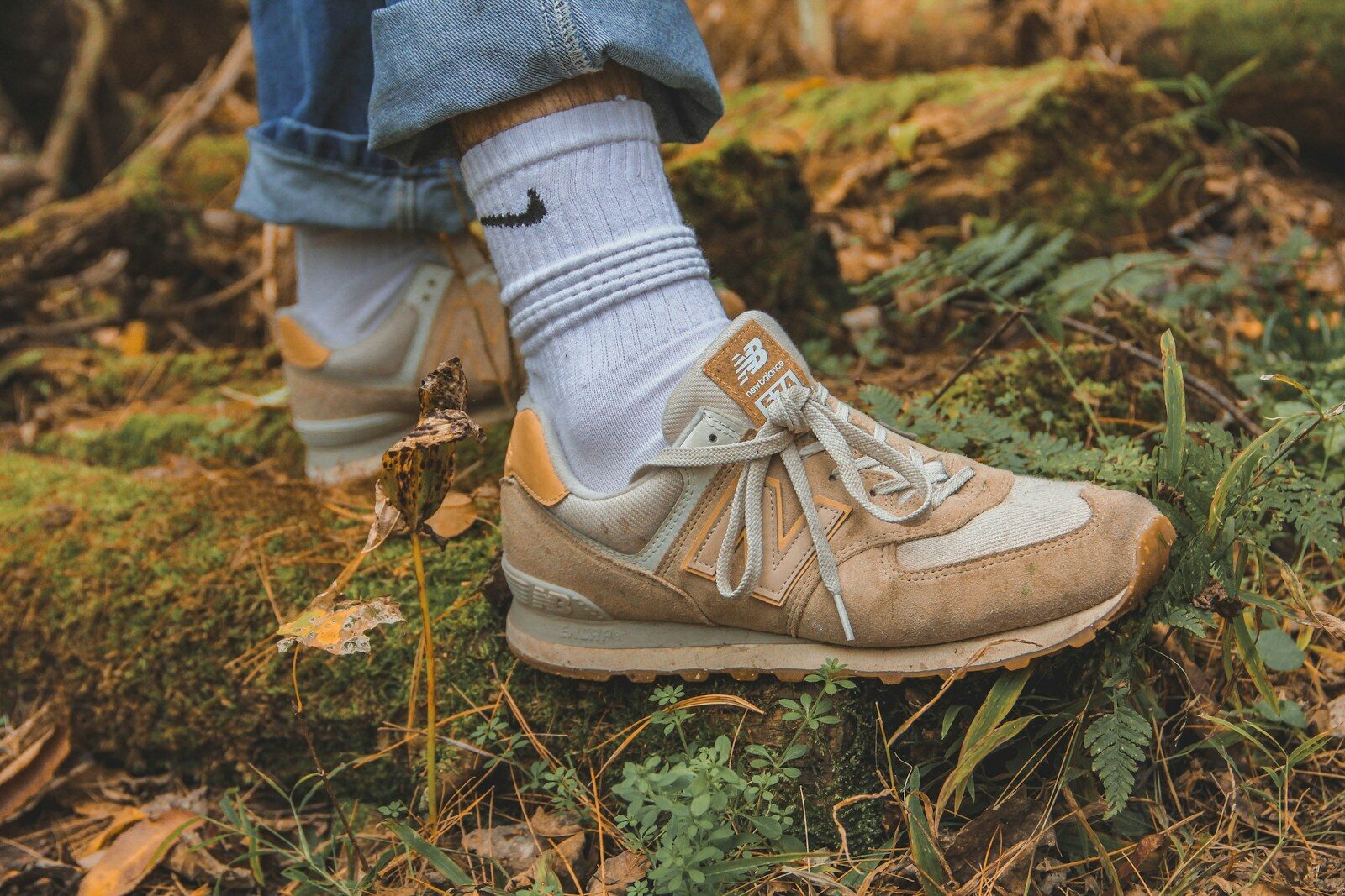 a person standing on a patch of grass wearing a pair of sneakers